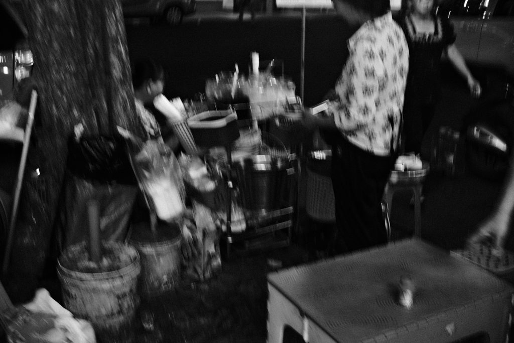 Tables basses et tabourets en plastique d'un restaurant de rue, sous un arbre