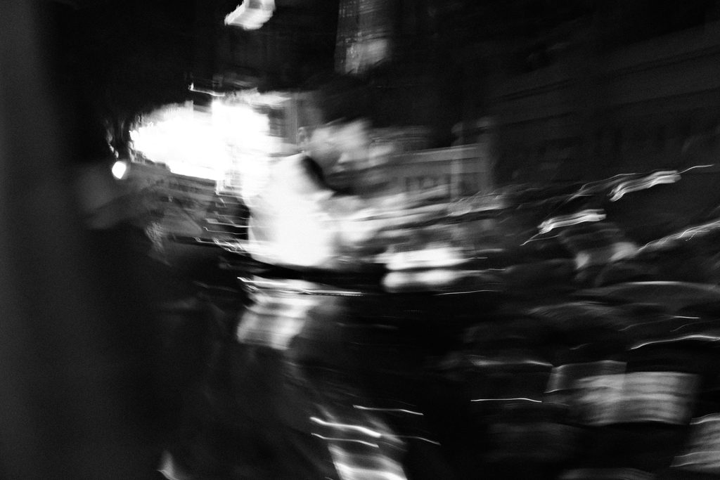 Lumières et silhouettes brouillées par le mouvement dans une rue de nuit