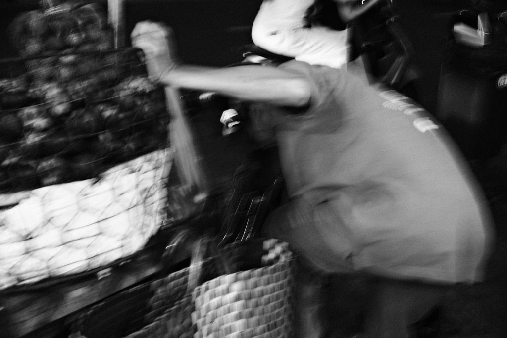 Femme penchée sur un étal de rue, saisie en mouvement