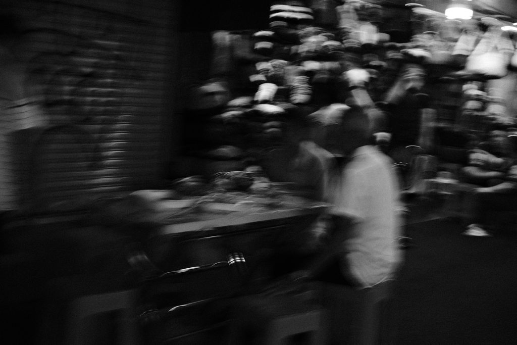 Silhouette floue d'un homme debout entre les tables d'un restaurant de rue