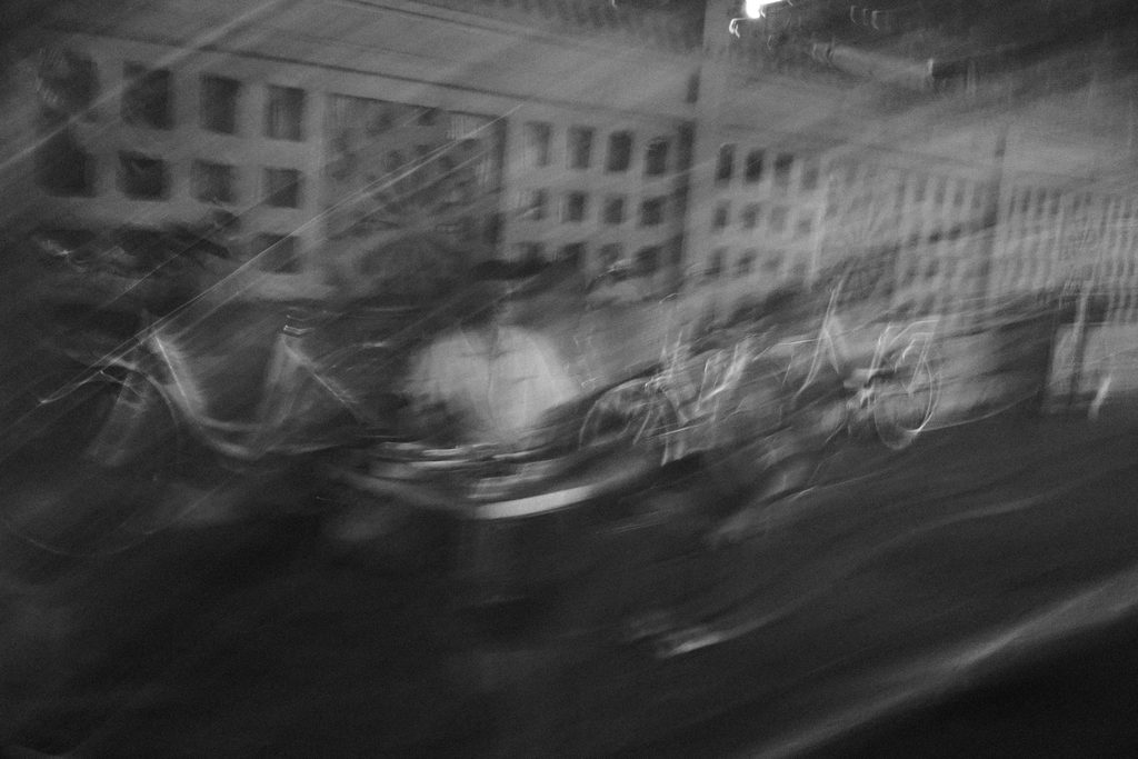 Façade d'immeuble et passants flous, la nuit
