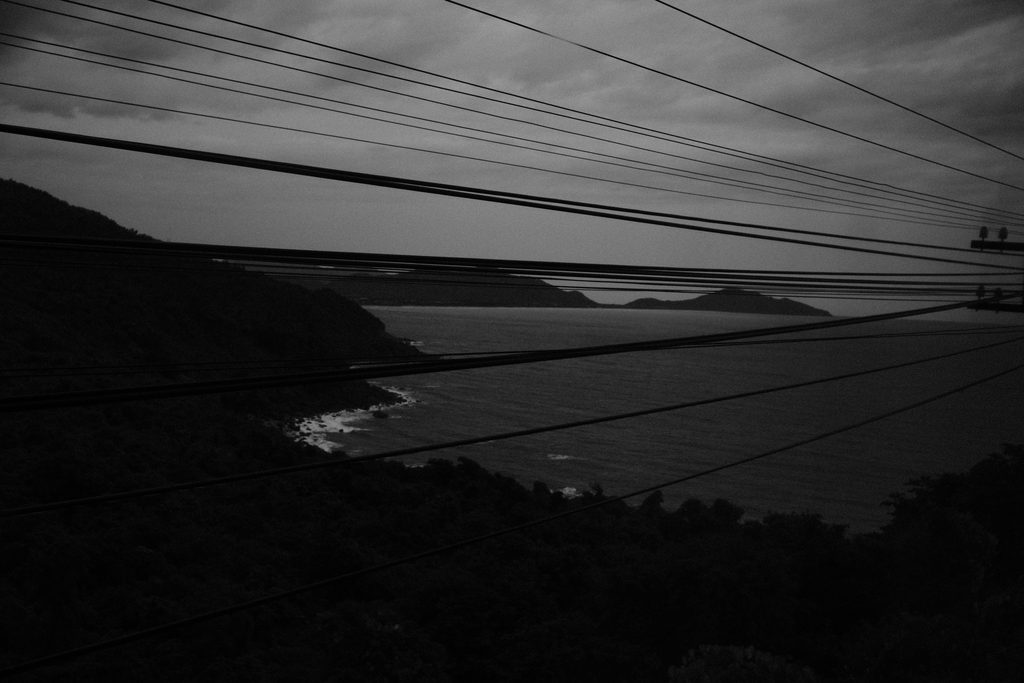 Côte et baie vues d'en haut, traversées par les câbles électriques