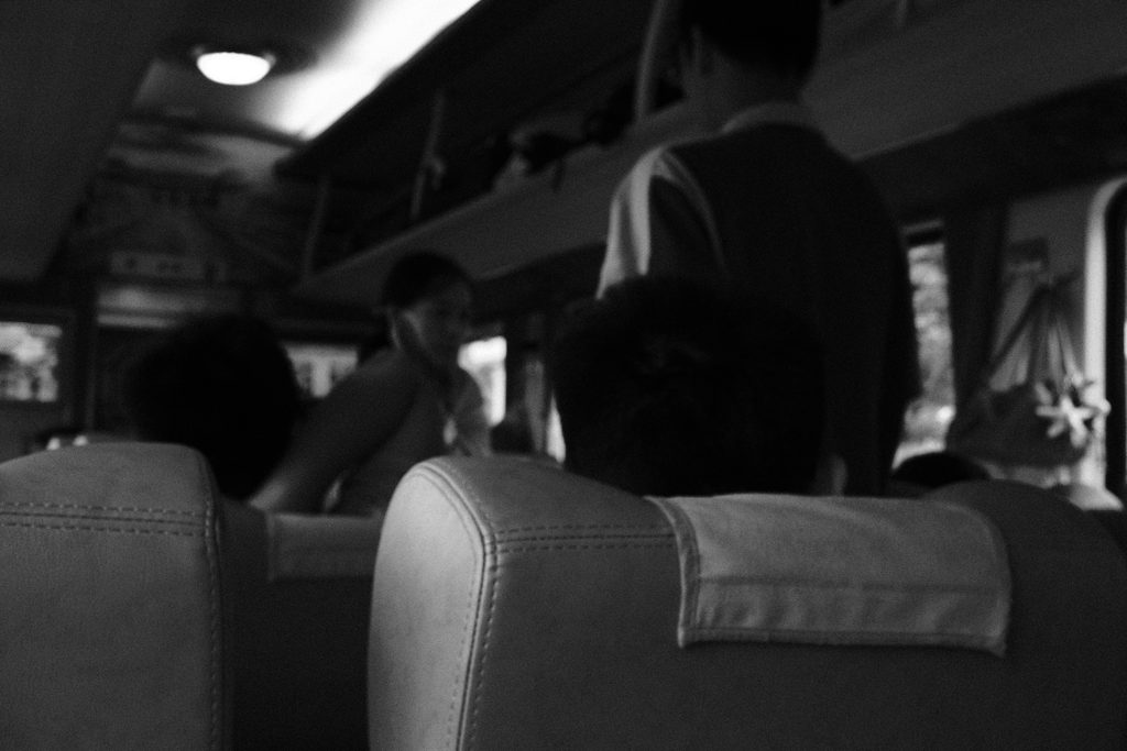 Intérieur d'un wagon : dossiers de sièges et voyageurs debout dans l'allée