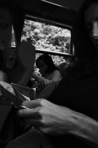 Mains repliant un papier de repas dans un wagon, près de la fenêtre