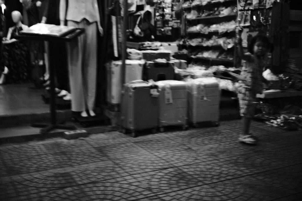 Un enfant joue devant une boutique de valises et de vêtements, à Hô Chi Minh-Ville, la nuit