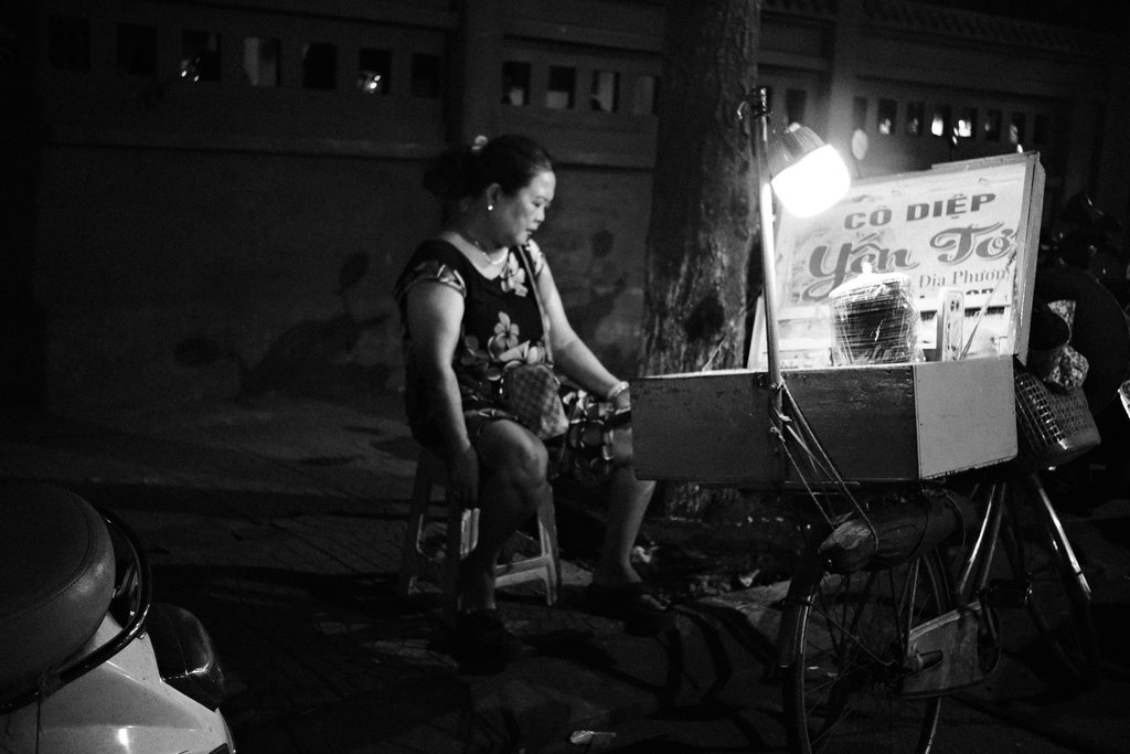 Vendeuse de rue près de son chariot éclairé, la nuit