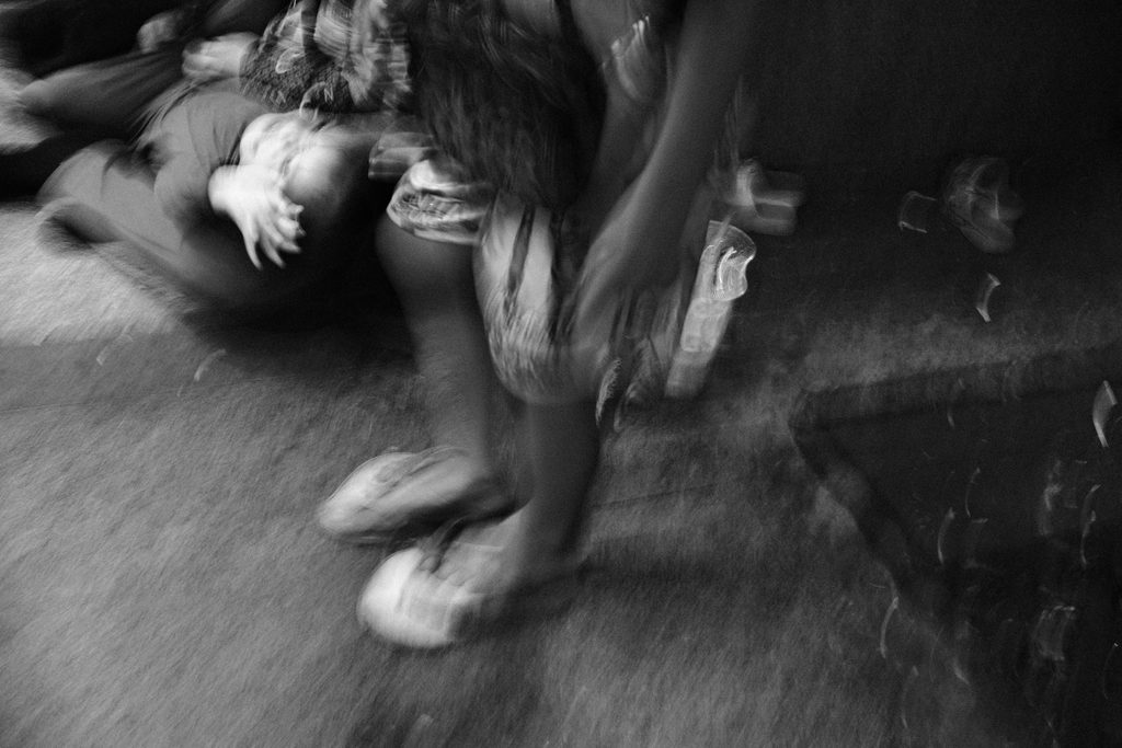 Pieds et jambes d'une passante en mouvement, près d'une personne allongée au sol