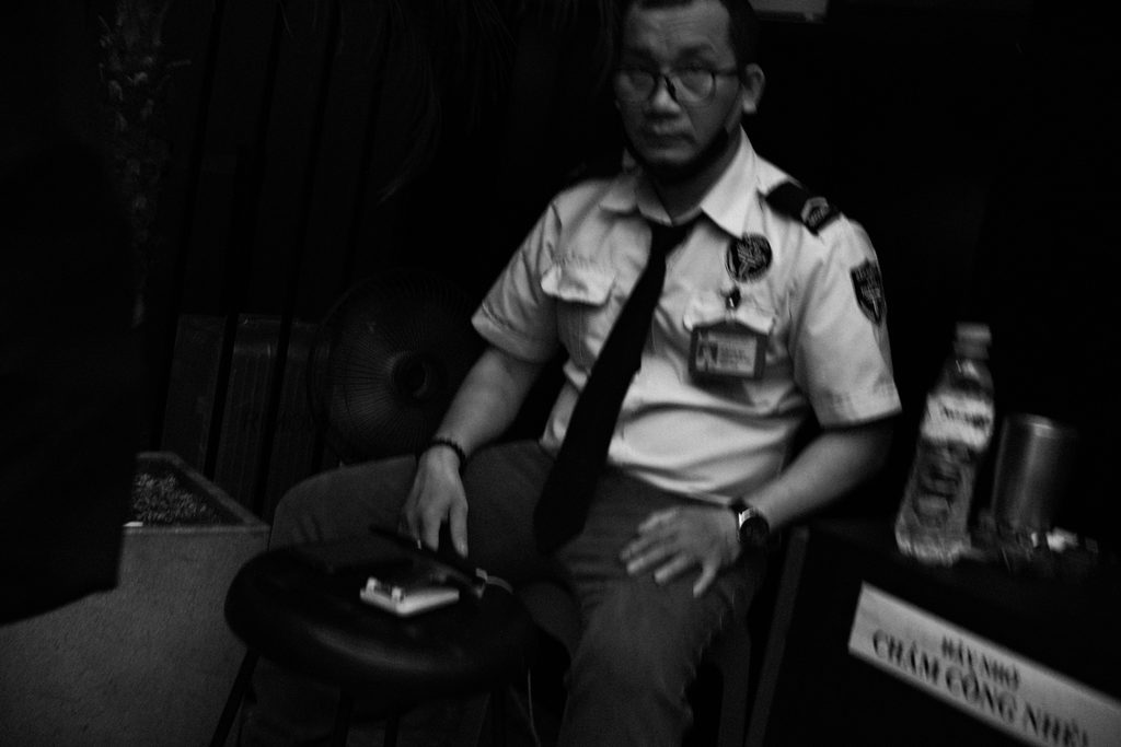 Agent de sécurité en uniforme assis sur une chaise, la nuit